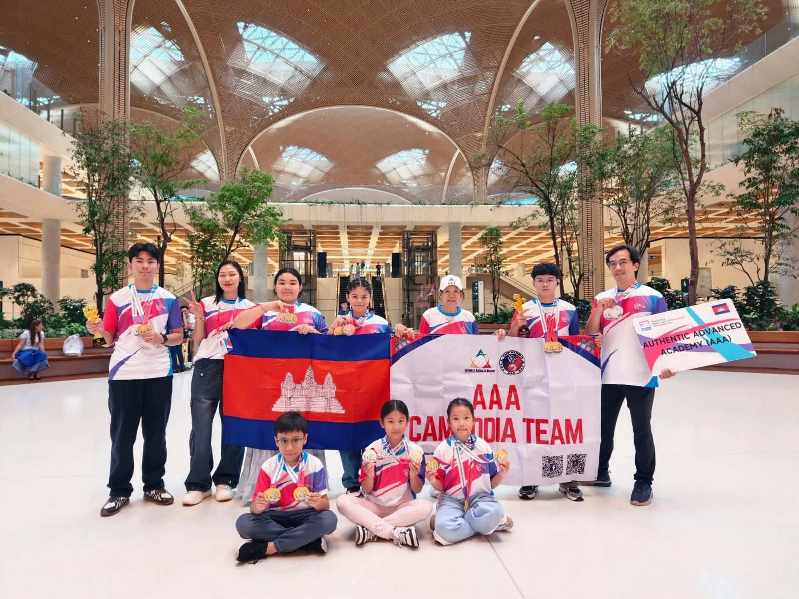 AAA’s Cambodia team with flags at the airport after the Singapore championship